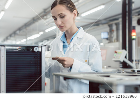 electrical engineer at assembly line inspecting PCB boards 121618966