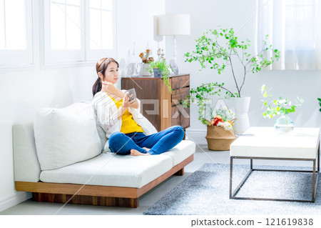 Young woman drinking coffee in the living room 121619838