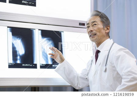 A veteran doctor explaining an X-ray of a shoulder joint A veteran doctor explaining an X-ray of a shoulder joint 121619859