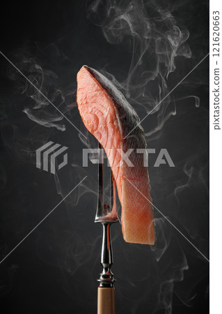 Smocked salmon piece with natural smoke on a black background. Smocked salmon piece with natural smoke on a black background. 121620663