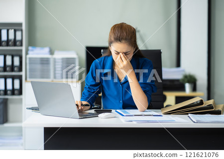 Serious woman cover her face after stressed with credit card debt sit at workplace desk in office use calculator calculates monthly expenses. 121621076