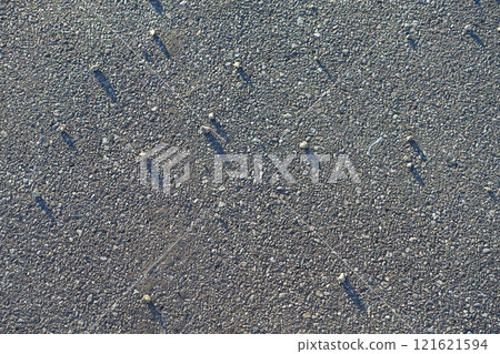 Pebbles rolling on asphalt background material 121621594