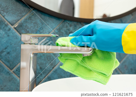 Person is cleaning a sink faucet, cleaning service Person is cleaning a sink faucet, cleaning service 121621675