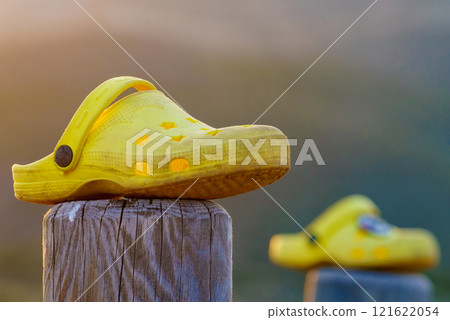 Shoes clogs outdoors against sunset light 121622054
