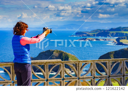 Tourist with camera on Asturias coast, Spain 121622142