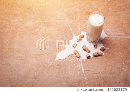 healthy diary food on rustic, spilled milk with peanuts on wooden background healthy diary food on rustic, spilled milk with peanuts on wooden background 121622179