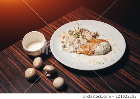 delicious chicken fillet with mushrooms on wooden table in restaurant 121622182