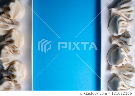 traditional georgian khinkali dumplings flatlay with copyspace, blue background 121622199