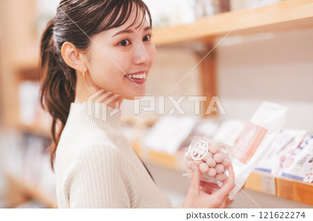 A young woman choosing souvenirs [Photo courtesy of Niigata Sweets Premium WAGASHI Japanese NAGOMI] 121622274