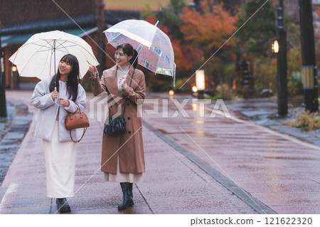 Two young women walking through a hot spring town in the rain [Filming cooperation: Shibata City Film Commission Council] 121622320