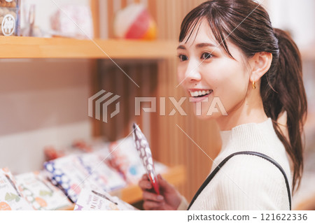 A young woman choosing souvenirs [Photo courtesy of Niigata Sweets Premium WAGASHI Japanese NAGOMI] 121622336