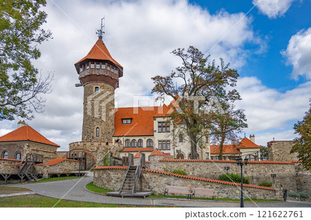Hnevin Castle in Most, Czechia features remarkable stonework and a distinctive tower. Visitors enjoy the scenic grounds under a cloudy sky, perfect for exploring the rich history. Hnevin Castle in Most, Czechia features remarkable stonework and a distinctive tower. Visitors enjoy the scenic grounds under a cloudy sky, perfect for exploring the rich history. 121622761