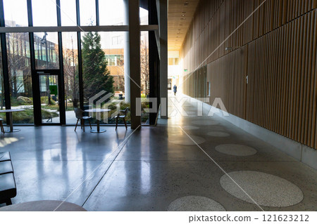 Hall in a modern building with large glass windows and a sitting area. Hall in a modern building with large glass windows and a sitting area. 121623212