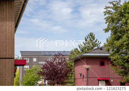 Residential building with new roof and solar panels. Real estate investment. Expensive housing. 121623275