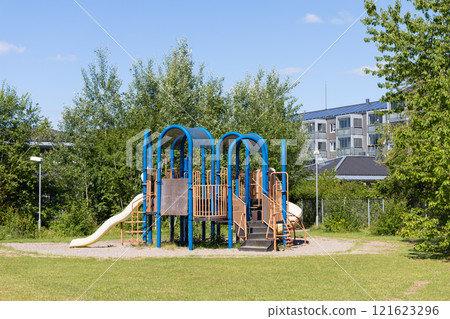 Children playground next to residential buildings on a sunny day. Children playground next to residential buildings on a sunny day. 121623296