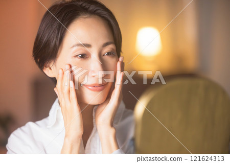 晚上在客廳做皮膚護理的中年婦女 121624313