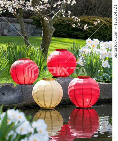 serene scene of red and gold lanterns floating in pond surrounded by flowers. , Lunar New Year serene scene of red and gold lanterns floating in pond surrounded by flowers. , Lunar New Year 121624521