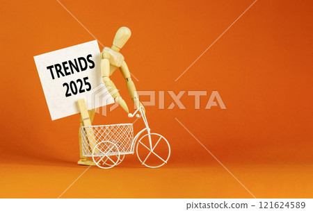Planning trends 2025 new year symbol. Concept words Trends 2025 on beautiful white paper on wooden clothespin. Bicycle. Beautiful orange background. Business trends 2025 new year concept. Copy space. 121624589