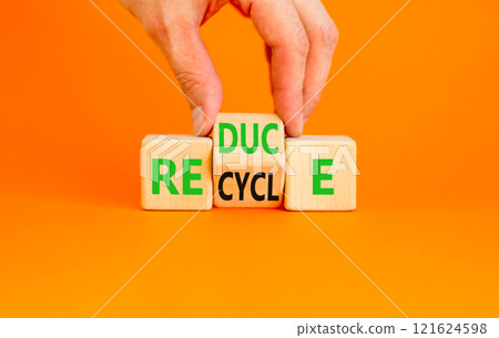 Reduce or recycle symbol. Concept words Reduce Recycle on wooden block. Beautiful orange table orange background. Businessman hand. Business reduce or recycle concept. Copy space. 121624598