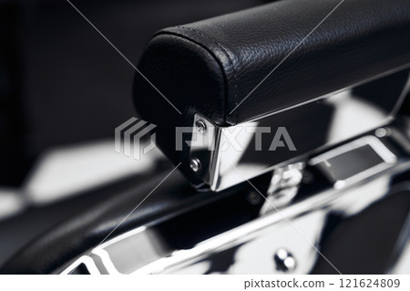 Close-up of a modern leather chair armrest in a stylish interior setting 121624809