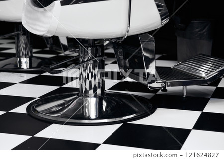 Classic barbershop interior showcasing stylish chairs and checkered floor design 121624827