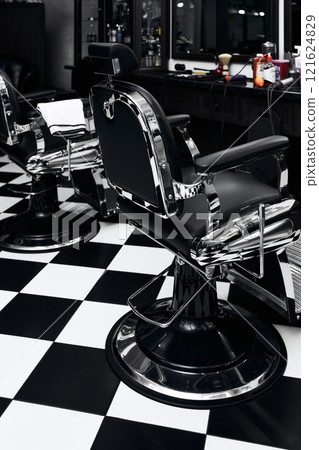 Stylish barber chairs in a modern barbershop with black and white decor Stylish barber chairs in a modern barbershop with black and white decor 121624829