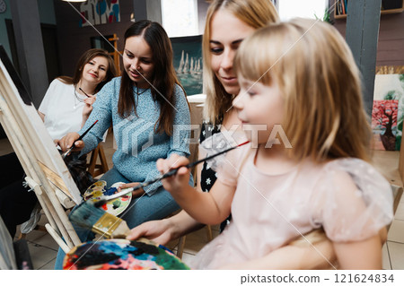 Art class with children and adults creating masterpieces in a sunny studio Art class with children and adults creating masterpieces in a sunny studio 121624834