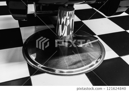 Reflections on a shiny bar stool and contrasting checkered floor 121624840