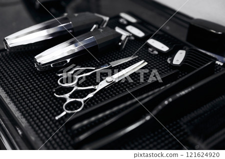 Professional barber tools neatly arranged on a work surface in a salon 121624920