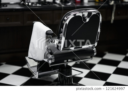 Classic barber chair in a vintage barbershop setting with checkered floor 121624997