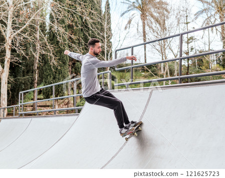 Young Skateboarder Performing Trick at Skatepark. Young Skateboarder Performing Trick at Skatepark. 121625723