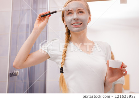 Woman with grey clay mud mask on her face Woman with grey clay mud mask on her face 121625952