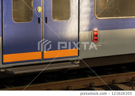 The striking blue train doors stand prominently at a busy station, highlighting their sleek design and welcoming commuters as the vibrant environment hums with anticipation 121626103