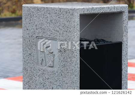 A modern concrete garbage container stands firm, encouraging responsible waste disposal and recycling 121626142