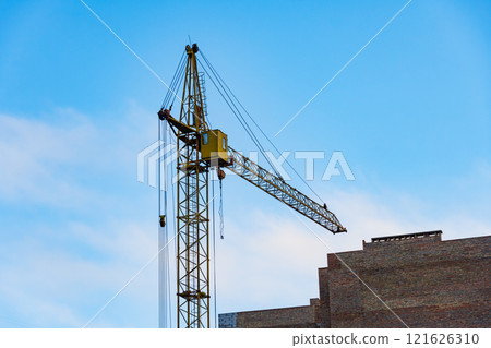 Two cranes are actively engaged at a large construction site, lifting materials high above the ground. This urban development project showcases industrial activity in a bustling skyline Two cranes are actively engaged at a large construction site, lifting materials high above the ground. This urban development project showcases industrial activity in a bustling skyline 121626310