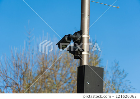 CCTV camera positioned on a sturdy pole oversees a public space, providing constant monitoring to ensure safety and security for the surrounding area 121626362