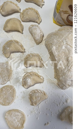 Homemade Dumplings Prepared on a Floured Surface with Dough and Ingredients 121626609