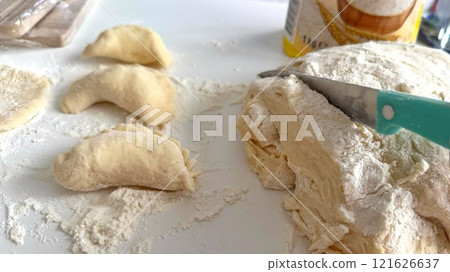 Traditional Ukrainian dish, Preparing Dough and Crafting Dumplings on a Flour-Dusted Surface Traditional Ukrainian dish, Preparing Dough and Crafting Dumplings on a Flour-Dusted Surface 121626637