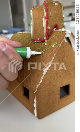 Crafting a Gingerbread House with Colorful Icing and Festive Decorations Crafting a Gingerbread House with Colorful Icing and Festive Decorations 121626638