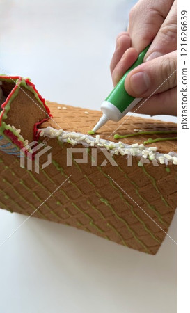Crafting a Decorative Gingerbread House with Green and White Icing Accents Crafting a Decorative Gingerbread House with Green and White Icing Accents 121626639