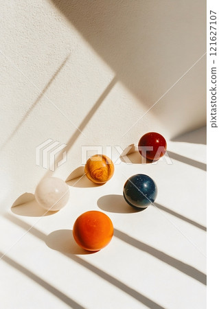 Colorful marbles casting shadows on white background 121627107