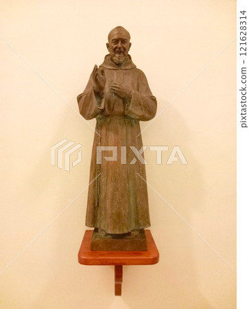 Statue of a blessing monk in a church 121628314