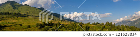 Panoramic View of Lush Green Hills Under Blue Sky 121628834