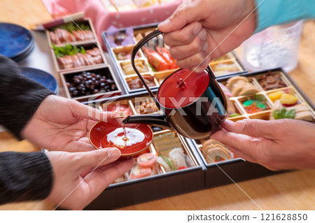 父母與孩子以時令菜餚倒年酒的場景 父母與孩子以時令菜餚倒年酒的場景 121628850