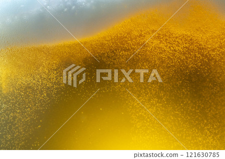 A scene of cold beer being poured into a glass and foam appearing 121630785