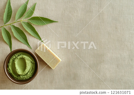 Flat lay view of neem leaves and herbal products on a textured surface 121631071