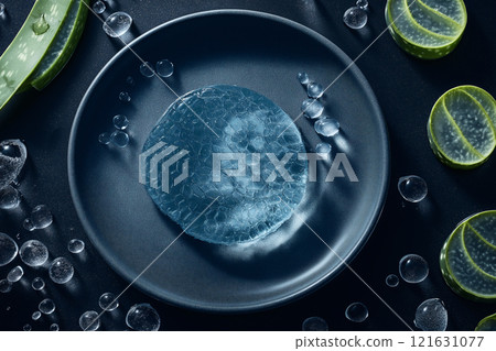 Top-down view of fresh aloe vera gel surrounded by slices and water droplets 121631077