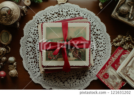 Elegant collection of vintage postcards tied with a red ribbon on a lace doily 121631202