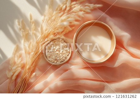 Oat grains and milk elegantly arranged on soft pastel fabric in a serene setting 121631262