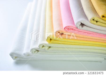 stack of colourful cotton clothes, pile of clothing on white background 121631473
